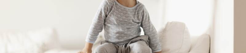 Child in pajamas sitting on a couch